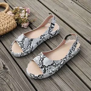 Detailansicht flacher Damensandalen mit stilvollem schwarz-weißem Schlangenmuster-Design.
