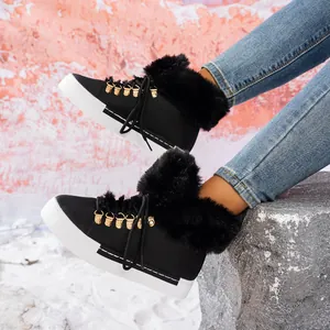 Vista detallada de botas de nieve negras para mujer con ribete de pelo y suela blanca gruesa