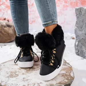 Detalle de botas de nieve negras para mujer con ribete de piel gruesa y suela de plataforma.