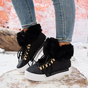 Primer plano de botas de nieve negras con piel sintética y suelas de plataforma blancas