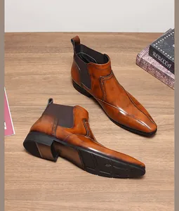 Vue détaillée de bottines Chelsea en cuir marron avec bout pointu et détails brogue