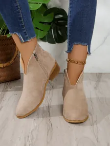 Vista detallada de botines Chelsea beige de ante con elegante corte en V y tacón