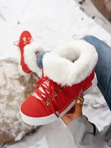Primer plano de botas de nieve rojas para mujer con piel sintética y suela gruesa