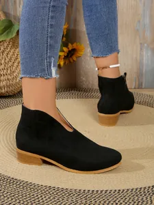Vista lateral de botines negros para mujer con cuello en V, tacón ancho y punta