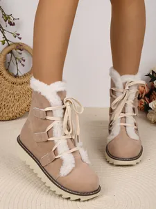 Gros plan détaillé de bottes de neige beiges à lacets avec doublure chaude en fausse fourrure