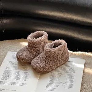 Bottines confortables en fausse fourrure pour bébé sur un livre