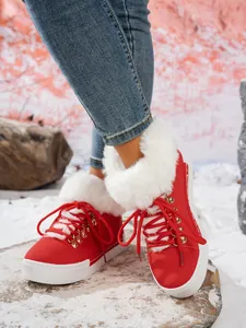 Vista detallada de botas rojas de invierno con ribete de pelo blanco y cordones