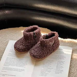Bottes d'hiver marron en peluche pour tout-petits avec détail cœur sur un livre