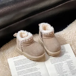 Toddler beige suede snow boots with white fleece lining on a cozy rug detail view