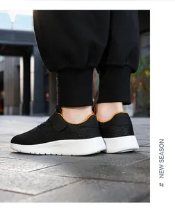 Vista detallada de zapatillas de running de malla negra transpirable para niños con forro naranja