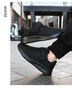 Detalle de zapatillas negras transpirables para niños con cierre de velcro cómodo