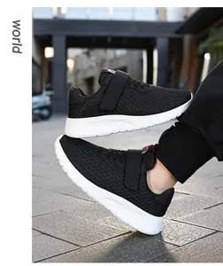 Vista detallada de zapatillas de malla negra transpirable para niños con suela blanca