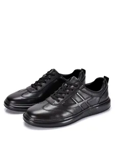 Vista detallada de las zapatillas casuales de cuero genuino negro para hombre con suela blanda.