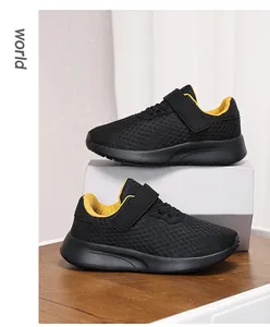 Vista lateral de zapatillas deportivas de malla transpirable negro y amarillo niño