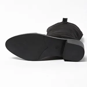 Macro detail view of anti-slip sole and block heel on black suede pointed-toe boots