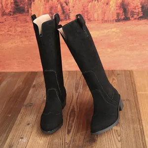 Detail view of black suede knee-high boots with pointed toe and block heel