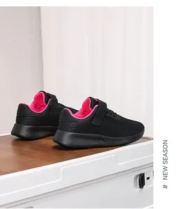 Vista detallada de zapatillas de correr para niños en malla negra con forro interior rosa