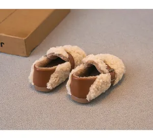 Vista detallada de mocasines cálidos para niños forrados con sherpa y talón de cuero
