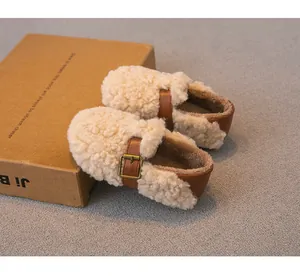 Detalle de zapatos de lana de oveja rizada para niñas con hebillas de cuero