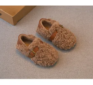 Primer plano de mocasines acogedores para niños de lana rizada con hebilla y forro