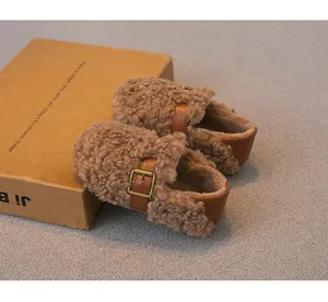 Primer plano de mocasines acogedores de lana de cordero para niños con hebilla