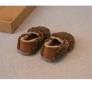 Vista trasera de mocasines de borreguito marrones para niños con forro cálido.