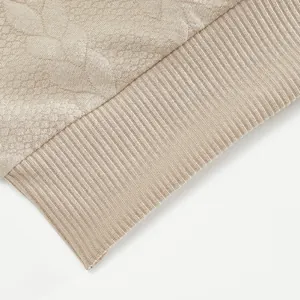 Detailopname van beige jacquardstof en geribbelde zoom op zware kwaliteit sweater