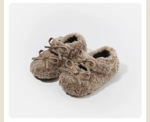 Primer plano de acogedores zapatos de peluche marrón para bebé con lazos decorativos