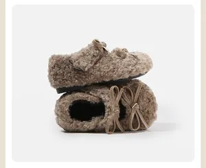 Primer plano detallado de zapatos para bebé de felpa marrón con adorables detalles de lazo