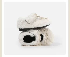 Vista detallada de zapatos de felpa blancos para bebés con lazo elegante y forro suave