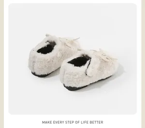 Vista detallada de zapatos de bebé peludos en crema con forro cálido y detalle de lazo