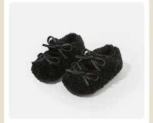 Primer plano de zapatos de peluche negro para bebés con lazos dobles de cuero