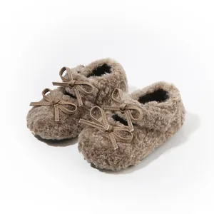 Zapatos de peluche marrón para bebés con lazos decorativos para el calor del invierno.