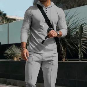 Λεπτομέρεια ανδρικής γκρι φόρμας με πλέξη βάφλα, με μπλούζα με κουκούλα και παντελόνι