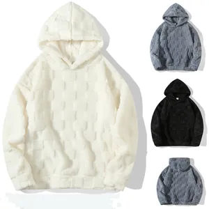 Detailansicht der Lammwoll-Hoodies mit Schachbrettmuster in den Farben Weiß Schwarz Grau