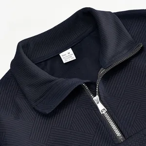 Close-up van het getextureerde donkerblauwe jacquardpatroon en het neklabel van dit sweatshirt