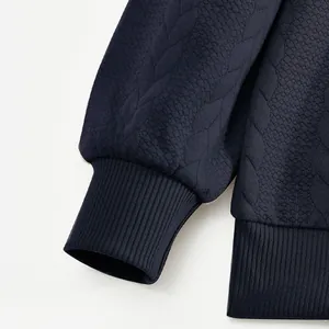 Detailopname van marineblauwe jacquardstof en de geribbelde manchet van sweatshirt