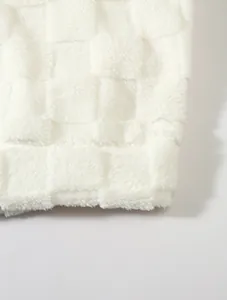 Detailaufnahme des weichen, weiß karierten Lammwoll-Fleece-Stoffs des Kapuzenpullovers