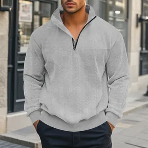 Detailopname van een grijze herensweatshirt met jacquardpatroon en opstaande kraag.