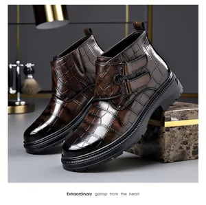 Vista detallada de botas de hombre con relieve de cocodrilo marrón y hebillas.