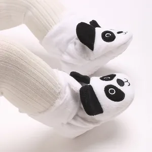 Vue détaillée de chaussons pour bébé en forme de panda en tissu peluche blanc et doux.