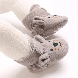 Gros plan de bottines d'hiver grises pour bébé avec motif ours et doublure douce