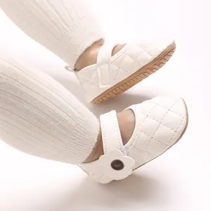 Détail de chaussures de princesse matelassées blanches pour bébé avec fleur et semelle.