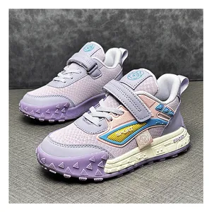 Close-up of children's purple and pink sports sneakers with textured leather and rugged sole.