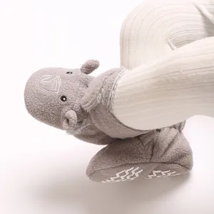 Vue détaillée de chaussons bébé en polaire grise avec un motif de dessin animé mignon