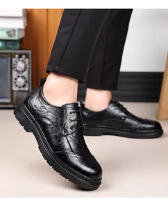 Close-up view of black hand-textured leather oxford shoes worn with black trousers