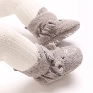 Gros plan de bottines en peluche grise pour bébé avec broderie éléphant mignonne.