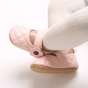 Détail de chaussures bébé roses en similicuir matelassé avec fleur et semelle antidérapante