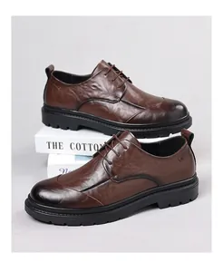 Detailed side view of brown textured leather derby shoes with thick black rubber soles