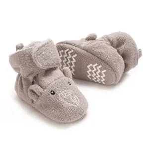 Gros plan sur un chausson bébé en polaire grise avec broderie éléphant et semelle zigzag